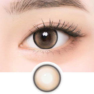 i-Girl IG Cream Brown color contact lens on top of a dark eye paired with subtle eye makeup and curled wispy eyelashes, above the contact lens design.