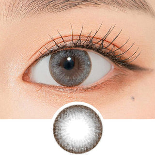 Close-up shot of a model's eye wearing Lensrang Snug Grey color contacts with prescription, paired with K-beauty-inspired eye makeup, showing the brightening and enlarging effect of the circle contact lens on dark brown eyes, above a cutout of the contact lens pattern with limbal ring on a white background.