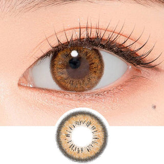 Close-up shot of a model's eye wearing Lensrang Spell Brown color contacts with prescription, paired with K-beauty-inspired eye makeup, showing the brightening and enlarging effect of the circle contact lens on dark brown eyes, above a cutout of the contact lens pattern with limbal ring on a white background.