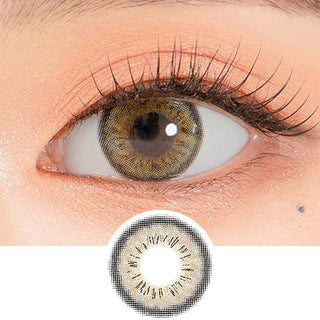 Close-up shot of a model's eye wearing Lensrang Spell Grey color contacts with prescription, paired with K-beauty-inspired eye makeup, showing the brightening and enlarging effect of the circle contact lens on dark brown eyes, above a cutout of the contact lens pattern with limbal ring on a white background.