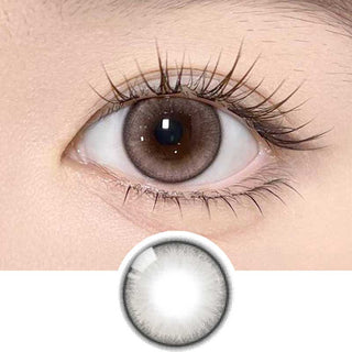 Olala Meow Kitten Beige color contact lens on top of a dark eye paired with subtle eye makeup and curled wispy eyelashes, above the contact lens design.