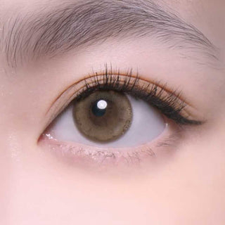 Close-up of one eye wearing EyeCandys Merry Mocha prescription colored contact lens – natural color contact lenses paired with long lashes and feathery brows.