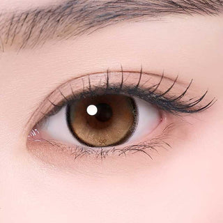 i-Sha Reborn Oak Haze color contact lens on top of a dark eye paired with subtle eye makeup and curled wispy eyelashes