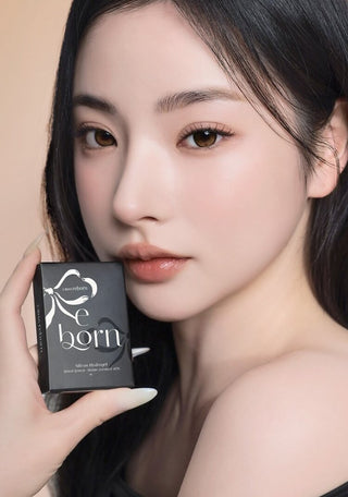 A female model with natural dark eyes wearing i-Sha Reborn Oak Haze contact lenses, complemented by subtle eyeshadow and peach lipstick