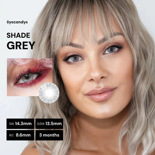 A woman with light blonde hair wears EyeCandys Shade Grey contact lenses, looking at the camera. Text reads: "EyeCandys Shade Grey." Lens details: DIA 14.3mm, G.DIA 13.5mm, B.C 8.6mm, 3-month use—perfect cosmetic contacts.