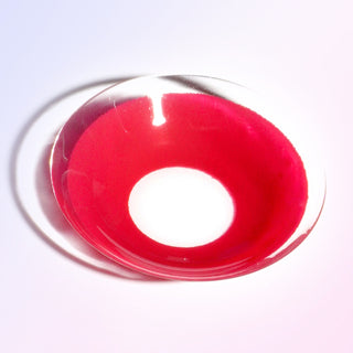 Macro shot of the EyeCandys red cosplay prescription colored contact lens on a white background, highlighting the intricate details and pattern of the lens design.