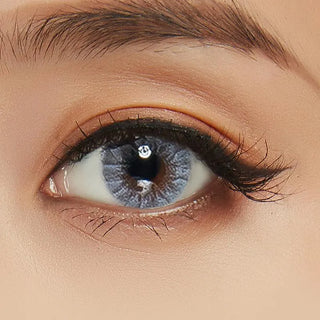 Close-up shot of a model wearing Shade Blue prescription colored contact lens in one eye that is naturally dark-brown