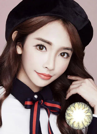 The image showcases a model wearing Soony Brown contact lenses and red lipstick accentuating her features. It offers a close-up of her eyes enhanced by the contact lenses, which contrast beautifully with her natural dark eye color. Below, there is a cut-out image displaying the same lens.