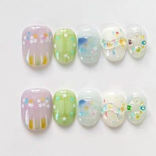 EyeCandys Sprinkle Season press on nails with pastel lavender jelly base, sky blue ink wash nails, and multicolor confetti glitter with crystal accents.