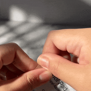 Step one of applying EyeCandys Gel Nail Stickers: wiping nails with an alcohol pad for a clean surface, ensuring perfect adhesion for a flawless gel manicure