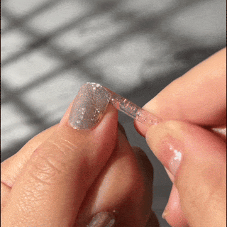 Step 10 of removing EyeCandys Gel Nail Stickers: gently removing the sticker with a stick for safe, easy removal while preserving nail health for future use