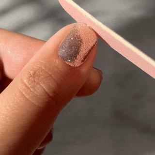 Step five of applying EyeCandys Gel Nail Stickers: filing the sticker and nail for a smooth, seamless finish, ensuring a flawless and durable gel manicure