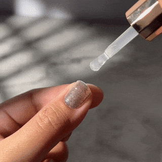 Step eight of applying EyeCandys Gel Nail Stickers: applying top glaze for an extra glossy, durable finish and long-lasting, salon-quality gel manicure