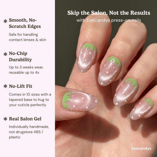 Close up hand showcasing EyeCandys Strawbelina press on nails with rosy pink shimmer nails and green strawberry tip design.