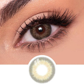 Close-up view of EyeCandys Sugarlook brown contact lens on a model's dark eye, paired with natural eye makeup, above the graphic design of the brown eye contacts.
