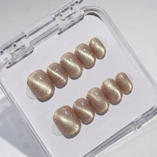 EyeCandys Velvet Taupe press on nails featuring warm taupe brown cat-eye nails with holographic gold glitter and glossy finish in a short round shape.