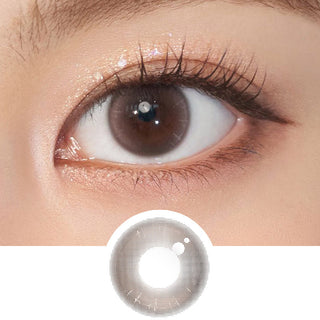 Close-up shot of model's eye adorned with Chuu Aube Pie Moon Brown daily color contact lenses with prescription, complemented by clean eye makeup, showing the brightening and enlarging effect of the circle contact lens on dark brown eyes, above a cutout of the contact lens pattern with limbal ring on a white background.