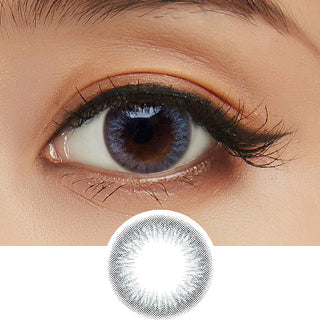 Close-up shot of model's eye adorned with Clalen Iris Blue Moon (30pk) daily color contact lenses with prescription, paired with clean-girl eye makeup, showing the brightening and enlarging effect of the circle contact lens on dark brown eyes, above a cutout of the contact lens with limbal ring on a white background.