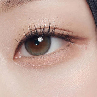 Close-up shot of model's eye adorned with Gemhour Demeter 1-Day Ash Grey (10pk) color contact lenses with prescription, complemented by minimalist eye makeup, showing the brightening and enlarging effect of the circle contact lens on dark brown eyes.