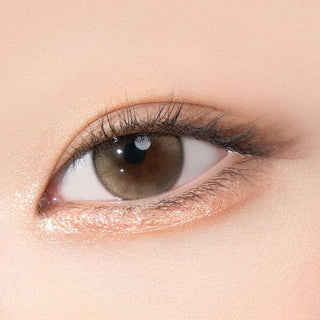 Close-up shot of model's eye adorned with Gemhour Demeter 1-Day Ash Brown (10pk) color contact lenses with prescription, complemented by minimalist eye makeup, showing the brightening and enlarging effect of the circle contact lens on dark brown eyes.