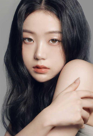 Asian model demonstrating a K-idol-inspired look with Gemhour Demeter 1-Day Ash Grey (10pk) coloured contact lenses, highlighting the instant brightening and enlarging effect of the circle contact lenses over dark irises.