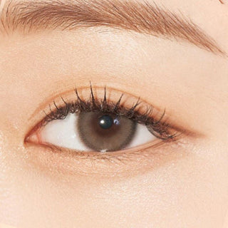 Close-up shot of model's eye adorned with Gemhour Everyday Essentials Beige color contact lenses with prescription, complemented by minimalist eye makeup, showing the brightening and enlarging effect of the circle contact lens on dark brown eyes.