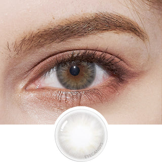 Close-up of model's eye featuring Pink Label Flirty Grey contact lens, complemented by peach eyeshadow, with a cut-out of the same lens below