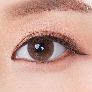 Macro shot of an eye wearing the Olola Mellows Cotton Brown (KR) prescription colour contact lens, showing the multi-colored detail and natural effect on dark brown eyes.