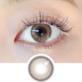 Close-up shot of model's eye adorned with Chuu Milk & Tea Cream Brown daily color contact lenses with prescription, complemented by clean eye makeup, showing the brightening and enlarging effect of the circle contact lens on dark brown eyes, above a cutout of the contact lens pattern with limbal ring on a white background.