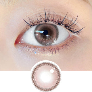 Close-up shot of model's eye adorned with Chuu Milk & Tea Cream Pink daily color contact lenses with prescription, complemented by clean eye makeup, showing the brightening and enlarging effect of the circle contact lens on dark brown eyes, above a cutout of the contact lens pattern with limbal ring on a white background.