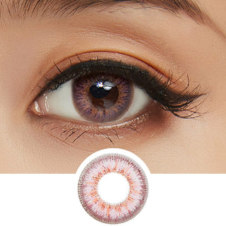 Close-up shot of model's eye adorned with Pink Label Obsession Pink color contact lenses with prescription, complemented by clean eye makeup, showing the brightening and enlarging effect of the circle contact lens on dark brown eyes, above a cutout of the contact lens pattern with limbal ring on a white background.