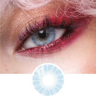 Close-up view of natural looking blue contact lens on a medium brown eye, paired with bold red eye makeup, next to a cutout of the contact lens