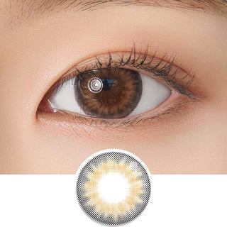 Close-up shot of model's eye adorned with Chuu Sunny Cookie Brown daily color contact lenses with prescription, complemented by clean eye makeup, showing the brightening and enlarging effect of the circle contact lens on dark brown eyes, above a cutout of the contact lens pattern with limbal ring on a white background.