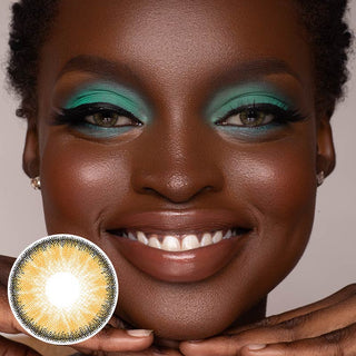 A black model with naturally dark brown eyes and green eyeshadow, wearing EyeCandys toffee brown contact lenses, showcases a joyful expression.