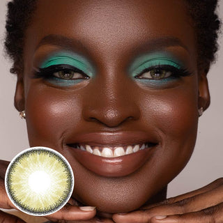A black model with naturally dark brown eyes and green eyeshadow, wearing EyeCandys sandy beige contact lenses, showcases a joyful expression.