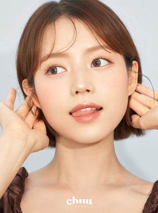 Asian model demonstrating a K-idol-inspired look with Chuu Milk & Tea Cream Grey coloured contact lenses, highlighting the instant brightening and enlarging effect of the circle contact lenses over dark irises.