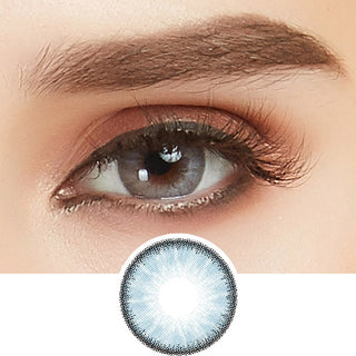 Close-up shot of a model eye wearing Desire Glacier Blue colored contact lens in one eye that is naturally dark-brown with natural ligth gold eye make up
