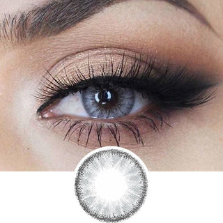 Macro shot of an eye wearing the desire mist grey colour contact lens, showing the light color detail and natural effect on dark brown eyes, with smokey eye makeup, with a cutout detail of the same lens below