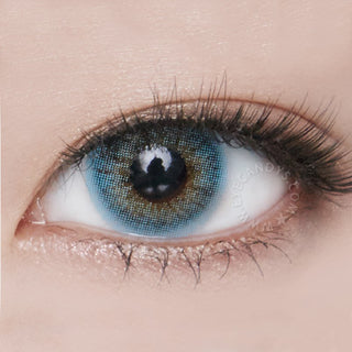 Close-up shot of a model wearing Blenz Chic Blue blended colored contact lens in one eye that is naturally dark-brown, paired with minimal Korean-inspired eye makeup.