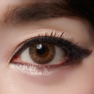 Close-up shot of a model wearing Tri-Color brown prescription colored contact lens in one eye that is naturally dark-brown