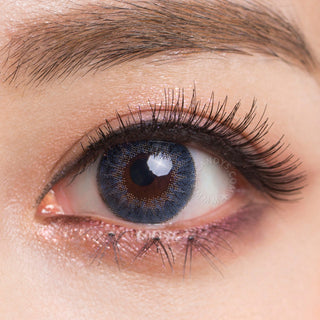 Close-up shot of a model wearing Tri-Color Blue prescription colored contact lens in one eye that is naturally dark-brown