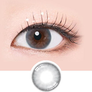 Macro shot of an eye wearing the i-Sha Serenity Grey prescription colour contact lens, showing the multi-colored detail and natural effect on dark brown eyes, with clean eye makeup. At the bottom is the pattern of the colored lens design, showing the dotted detail and pigmentation.