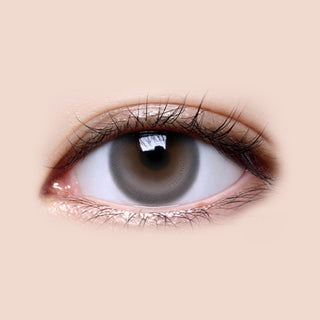 Close-up shot of model's eye adorned with LensMe LilMoon Skin Grey color contact lenses with prescription, complemented by minimalist eye makeup, showing the brightening and enlarging effect of the circle contact lens on dark brown eyes.
