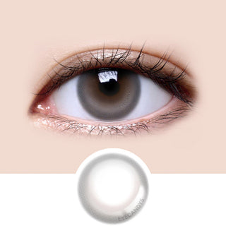 Close-up shot of model's eye adorned with LensMe LilMoon Skin Grey color contact lenses prescription, paired with clean-girl eye makeup, showing the brightening and enlarging effect of the circle contact lens on dark brown eyes, above a cutout of the contact lens with limbal ring on a white background.