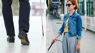 A person walking with a white cane next to a woman wearing sunglasses and holding a white cane on a platform.