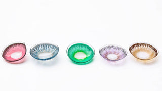 A group of colored contact lenses lined up together. Colors are red, blue, green, purple, and brown.