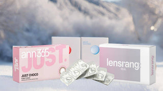 Boxes and blister packs of contact lenses in winter set against a snowy mountain background.