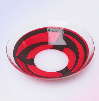 Macro shot of a Naruto Sharingan cosplay contact lens, showing the opaque pigmented detail, on a light background
