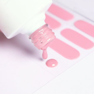 Close-up of EyeCandys pink nail stickers and nail polish drops falling from the bottle