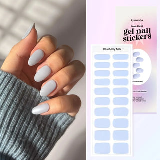  Close-up of hand with EyeCandys Blueberry Milk Gel Nail Stickers in a delicate pastel blue shade. Achieve trendy, long-lasting nails with a 7-free, allergy-friendly formula, perfect for spring. Cures in sunlight, lasting up to 2-3 weeks without a UV lamp.